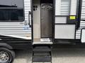A 2021 Jayco Jay Flight travel trailer with a step leading to the entrance door and a welcome mat at the doorway
