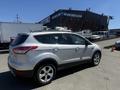 A silver 2014 Ford Escape parked with its side view visible showcasing its sleek design and alloy wheels