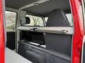 Interior view of a 2001 Toyota Dyna showing the seats and a storage area with a metal bar across the backrest