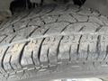 Close-up of a worn tire from a 2013 Chevrolet Express showing tread patterns and dirt on the surface