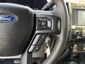 Close-up of the steering wheel and controls of a 2020 Ford F-350 SD including audio and phone buttons with a key attached