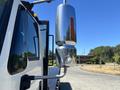 A 2018 International DuraStar truck with a chrome side mirror reflecting sunlight