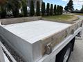A 2015 Ford F-350 SD truck with a flatbed featuring a wooden frame and metal edges designed for transporting cargo