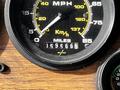 A close-up of a vintage speedometer displaying miles and kilometers per hour with a mileage reading of 0595662