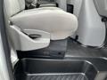 A close-up view of the interior of a 2009 Ford Econoline showing the driver's seat and floor area with gray fabric upholstery and a black rubber mat