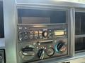 Dashboard of a 2013 Isuzu NPR featuring a radio display audio controls and knobs for climate settings