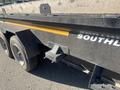 A 2024 Southland 18 foot dump trailer featuring a black exterior with a yellow stripe and a low profile design for hauling and dumping materials