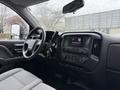 Interior view of a 2015 GMC Sierra 1500 featuring the dashboard steering wheel and infotainment system with a gray fabric seat