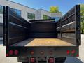 A 2015 RAM 5500 with an open truck bed featuring a flat wooden floor and metal sides ready for hauling cargo
