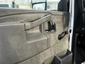 A close-up view of the driver's door panel of a 2017 Chevrolet Express featuring a window control handle and door lock mechanism