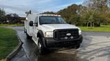 A 2007 Ford F-550 truck with a white exterior and utility body featuring lights and equipment on top