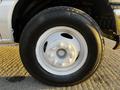 A close-up of a white wheel and tire of a 2017 Ford Econoline with a rugged tread pattern and multiple lug nut holes on the rim