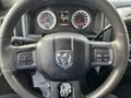 Steering wheel of a 2015 RAM 1500 featuring the RAM logo and control buttons for vehicle functions