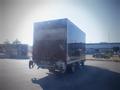 A 2013 Mitsubishi Fuso FE 160 box truck viewed from the rear showcasing its large cargo area and dual rear wheels