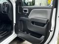 Interior door panel of a 2018 GMC Sierra 1500 featuring armrest and controls in a black and gray design