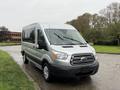 A silver 2019 Ford Transit van parked on a wet surface with a sleek design and large front grille