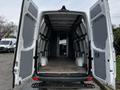 Interior of a 2016 Mercedes-Benz Sprinter van with open rear doors showing a spacious cargo area and metal supports on the walls