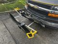 A 2018 Chevrolet Express with a bike rack mounted to the rear featuring yellow and black components designed to hold bicycles securely