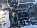 Interior of a 2016 Ford F-550 showing the gear shift lever cup holders and a rubberized floor mat