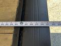 A tape measure extends across a wooden surface showing measurements ranging from 210 to 220 inches