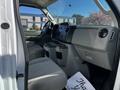 Interior of a 2019 Ford Econoline with gray seats and dashboard featuring controls and storage compartments