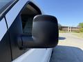 A side mirror of a white 2021 Chevrolet Express van