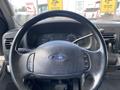 Steering wheel of a 2007 Ford F-350 SD with controls and dashboard gauges in the background