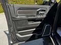 Interior door panel of a 2022 RAM 3500 featuring black leather trim power window controls and handle