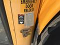 A close-up of the door latch and emergency door release mechanism on a 2007 Blue Bird Vision school bus