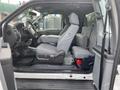 A 2015 Ford F-250 SD interior view showing two front seats with a center console and seat covers
