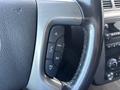Close-up of the steering wheel controls of a 2011 Chevrolet Avalanche featuring buttons for audio and phone functions