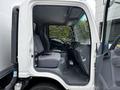Interior of a 2018 Isuzu NPR with two gray seated compartments and a steering wheel visible inside the cab