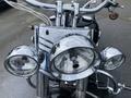 A close-up view of a chrome headlight assembly with three round headlights on a 2008 Harley-Davidson FLSTFI motorcycle