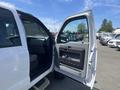 A white 2015 Ford F-550 truck with its driver's side door open showcasing the interior and seating area