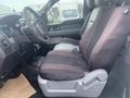 Interior of a 2013 Ford F-150 showcasing the driver's seat with a black and gray fabric cover and dashboard controls visible in the foreground