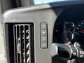 Close-up of the dashboard controls in a 2019 Chevrolet Express showing buttons for lights air conditioning and a checkmark symbol