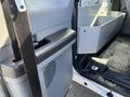 A 2013 Ford F-250 SD interior door handle and cabin area with part of a storage compartment visible
