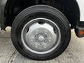 A close-up view of a black tire mounted on a silver wheel with six lug nuts on a 2019 Hino 195 vehicle