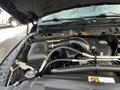 Close-up of the engine compartment of a 2015 RAM 1500 showing various engine components including the air intake and tubing