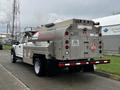 A 2018 Ford F-550 is equipped with a large metal fuel tank in the bed featuring flammable signs and various warning labels