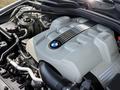 A close-up of a 2004 BMW 6-Series engine showcasing its sleek design and BMW emblem on the engine cover