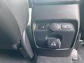 Close-up of a black control panel featuring two heated seat buttons and a power outlet in a 2015 Kia Sorento