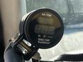 A digital temperature gauge displaying air temperature and road temperature readings attached to a vehicle interior