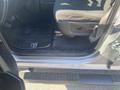 Interior view of a 2021 RAM 1500 showing the driver's side door open with a black floor mat and seat in focus