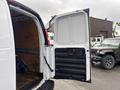 A 2022 GMC Savana cargo van with an open rear door revealing a spacious interior with wooden paneling and a rubber floor mat