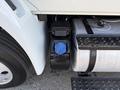 A close-up of the side of a 2017 International 4300 showing a blue cap on a tank near the rear wheel with visible metal and rubber components