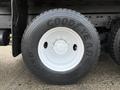 A close-up of a Goodyear tire on a 2016 International 7400 truck showcasing a large black tire with prominent tread and a white wheel rim