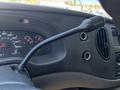 A close-up view of the dashboard controls of a 2008 Ford E-350 featuring a gear shift lever and various gauges including speedometer and temperature indicators