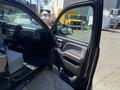 A 2014 GMC Sierra 1500 with an open driver's door showcasing the interior features and controls