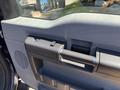 A close-up of the interior door handle and control panel of a 2014 Ford F-250 SD